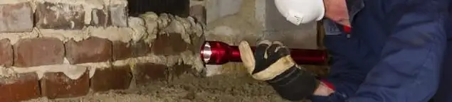 Pest control technician inspecting a crawl space for ant activity and entry points in Cedar Rapids, IA