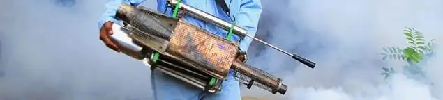 Fumigation technician using a fogger for deep pest treatment in Cedar Rapids, IA